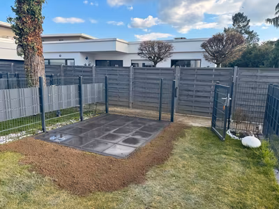 Mit dunklen Platten befestigte Fläche im Garten