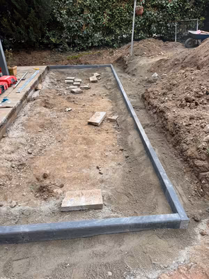 Rechteckige Einfassung aus Randsteinen in einer Gartenfläche