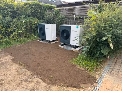 Zwei Wärmepumpen auf getrennten Fundamenten in einer Gartenfläche